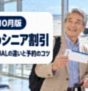 空港の出発ロビーで搭乗券とスマートフォンを手に笑顔の60代の日本人夫婦